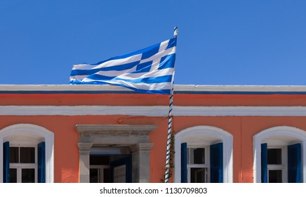 Greek flag in front of traditional building