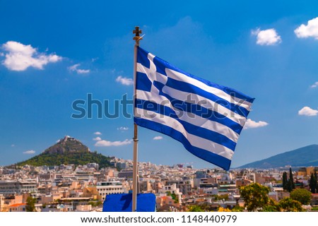 Greek flag waving waving over the city of Athens, the Greek capital