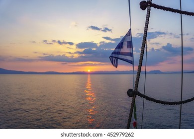 Greek Flag Waving At Sunset In The Messenian Gulf - Greece.