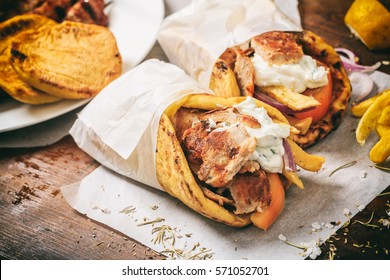 Greek food. Gyros souvlaki wrapped in a pita bread on a wooden background - Shutterstock ID 571052701
