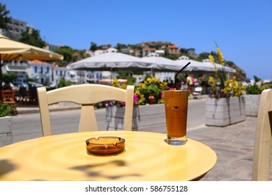 Greek Frappe Coffee And Ashtray On A Table At The Port Of Evdilos, Ikaria, North Aegean Islands