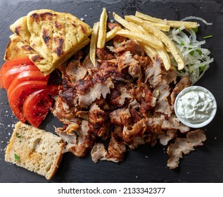 Greek Gyro Traditional Meat Food, Ethnic Dish, Meat Cut Into Thin Slice, Pita Bread And Tzatziki Yogurt On Black Color Background, Top View.