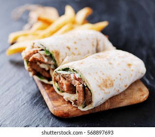 Greek Gyro Wrap Cut In Half And Served With Fries