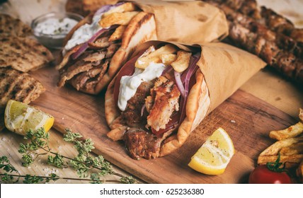 Greek gyros wrapped in pita breads on a wooden background - Shutterstock ID 625236380