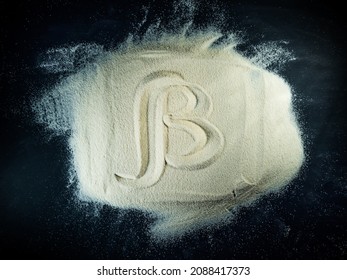 Greek letter beta written on a white sand with black background