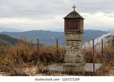 Greek Orthodox Christian Road Side Memorial Up In A Mountain At Winter Background View Of Mountain Hills And Clouds In Rainy Cloudy Day