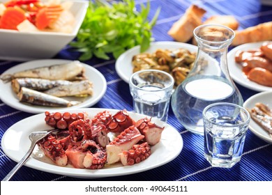 Greek Ouzo And Meze. Glasses And Bottle Of Ouzo And Seafood Appetizers