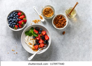 Greek Plain Yogurt With Fresh Berries Honey And Homemade Granola With Almonds, Overhead View, Space For A Text