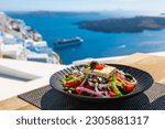 Greek salad with beautiful sea view in Santorini island, Greece. National greek cuisine concept. Travel and vacation