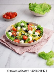 Greek Salad In A Plate On A Marble Background. Side View