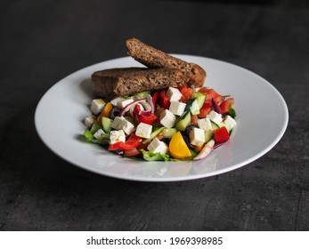 Greek Salad With Roasted Garlic Bread On The White Plate