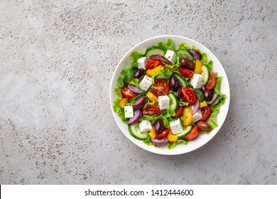 Greek Salad ( Tomato, Cucumber, Bel Pepper, Olives  And Feta Cheese) In White Bowl, Top View, Copy Space