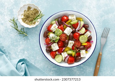 Greek salad. Vegetable salad with feta cheese, tomato, olives, cucumber, red onion and olive oil. Healthy vegetarian mediterranean diet food. Top view - Powered by Shutterstock