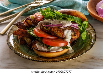 Greek Stuffed Turkey Burger Topped With Cucumber Slices And Tzatziki Yogurt Sauce Served With Mediterranean Street Cart Fried Potatoes With Feta Cheese Olives Herbs And Spices