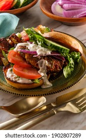 Greek Stuffed Turkey Burger Topped With Cucumber Slices And Tzatziki Yogurt Sauce Served With Mediterranean Street Cart Fried Potatoes With Feta Cheese Olives Herbs And Spices