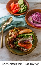 Greek Stuffed Turkey Burger Topped With Cucumber Slices And Tzatziki Yogurt Sauce Served With Mediterranean Street Cart Fried Potatoes With Feta Cheese Olives Herbs And Spices