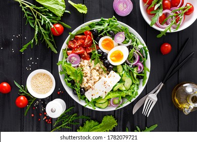 Greek style healthy breakfast bowl with oatmeal porridge and fresh vegetable salad of lettuce, arugula, olives, tomato, cucumber, feta cheese and boiled egg - Powered by Shutterstock