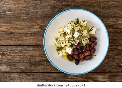 Greek style salad - feta cheese and kalamata olives on wooden table  - Powered by Shutterstock