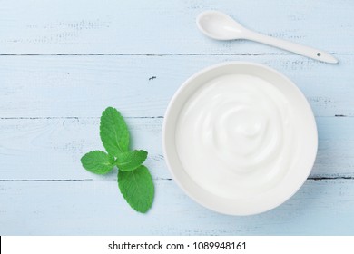 Greek yogurt in bowl decorated mint leaf on blue rustic table top view. - Powered by Shutterstock