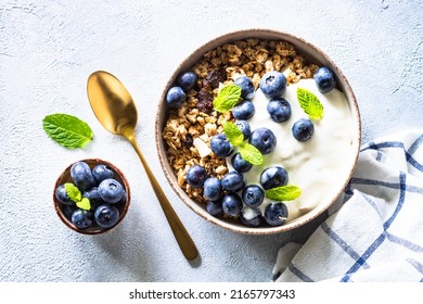 Greek Yogurt, granola and blueberry at light stone table. - Powered by Shutterstock