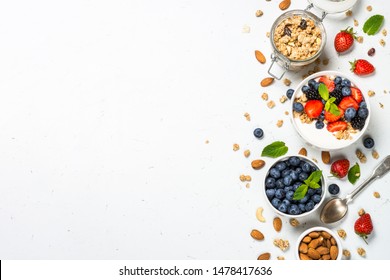 Greek yogurt granola with fresh berries on white table, top view, copy space. Healthy food, snack or breakfast.