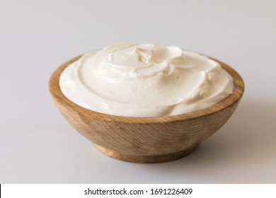 Greek yogurt in a wooden bowl. Healthy breakfast.Homemade Fatty Dairy product, sour cream, mayonnaise. - Shutterstock ID 1691226409