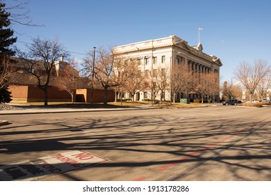 Greeley, Colorado, USA - February 7, 2021.  Angled View Of The Weld County Court.  Wintertime View With Blue Sky And Bare Trees.  Court In Greeley, CO. Roadway With Painted Sign In The Foreground. 