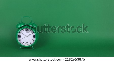green alarm clock on a green background