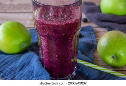 Green Apple Blueberry Smoothie Served In A Glass With Straw