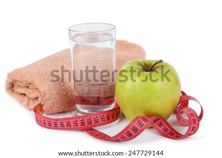 Green apple with measuring tape and glass of water isolated on white
