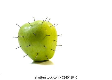 A Green Apple With Nails. The Idea Of Oversaturation Of Modern Food Products With Toxins And Chemicals. Or A Defensive Reaction To Something