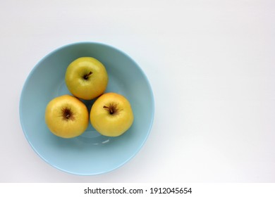 Green Apple On Blue Plate. Overhead View Of Fresh Fruits On White Table Background. Copy Space