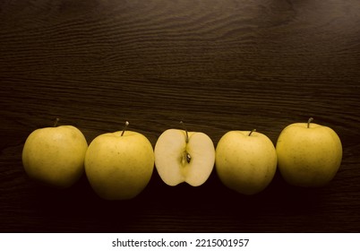 green apple and one half  of golden apple. Top view. wooden table surface.  - Shutterstock ID 2215001957