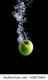 Green Apple Under Water With A Trail Of Transparent Bubbles.