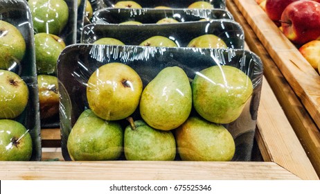 Green apples packed under plastic film