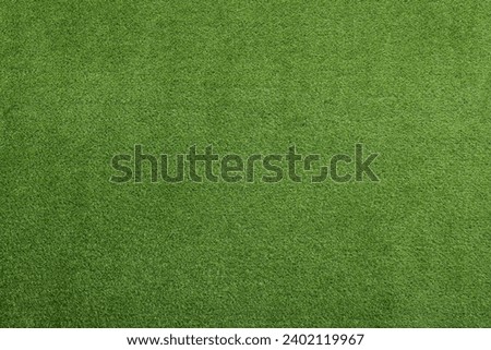 Green artificial grass as background, top view