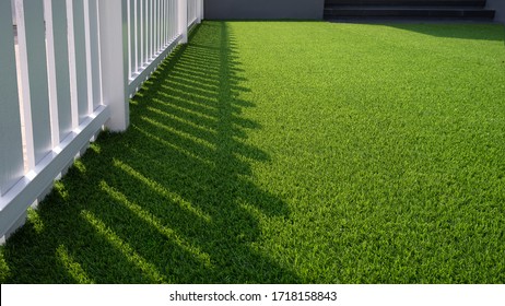 Green Artificial Turf and white Wooden Picket in Front Yard area at Home - Shutterstock ID 1718158843