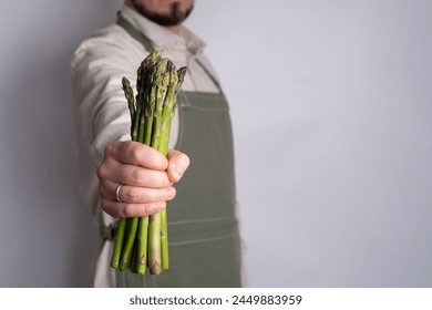 Green asparagus in the hands of a men. Bunch of ripe fresh asparagus. Healthy organic food. Cooking in home. Natural vitamins, raw ingredient for eating. Handpicked bio asparagus