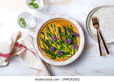 Green Asparagus, Sweet Peas Tart With Edible Chives Flowers Or Blossoms. Seasonal Spring Dinner Table, Overhead View. 