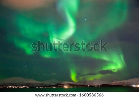 Green aurora burst in the sky of Tromso, Norway.
