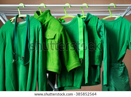 green baby clothes on hangers in the house