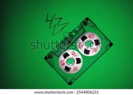 Green background with free space for text, Christmas music and 80's nostalgia theme with old audio cassette and Christmas tree from the tape. Red Christmas toys prints.