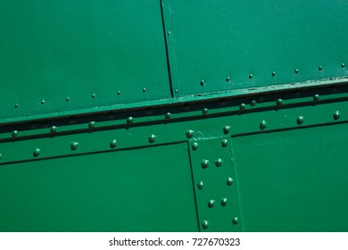The green background. Painted metal surface. The metal surface is sealed with rivets. Metal painted green. Diagonal turn