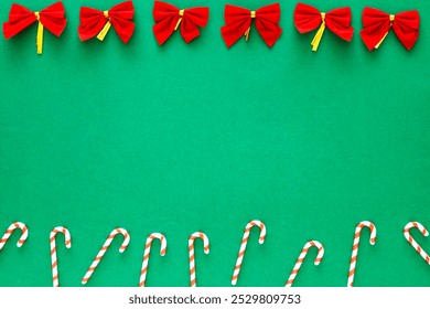 A green background with red bows and red and white striped candy canes. The candy canes are arranged in a row and the bows are placed above them. - Powered by Shutterstock