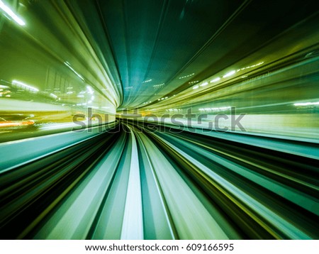 Green background of train moving through future rail tunnel bridge with blurred motion showing rapid movement.