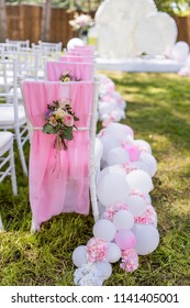 Green Backyard Decorated With Pink Balloons And Flowers Around Chairs And Wedding Altar