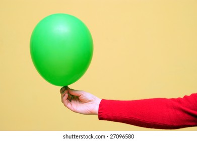 A green balloon being held in a hand