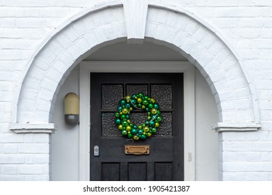 Green Baubles Form A Christmas Wreath On A Front Door Underneath An Alcove