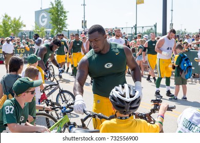 Green Bay, WI - August 1, 2017:  Green Bay Packer Kenny Clark Rides A Young Fans Bike After Football Practice.  The Community Owned Team Has A Long Tradition Of Player Involvement With Fans.