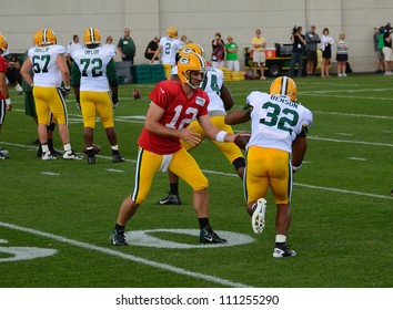 GREEN BAY, WI - AUGUST 19 : Green Bay Packers Quarterback Aaron Rodgers Hands Off The Football To Cedric Benson During Training Camp Practice On August 19, 2012 In Green Bay, WI